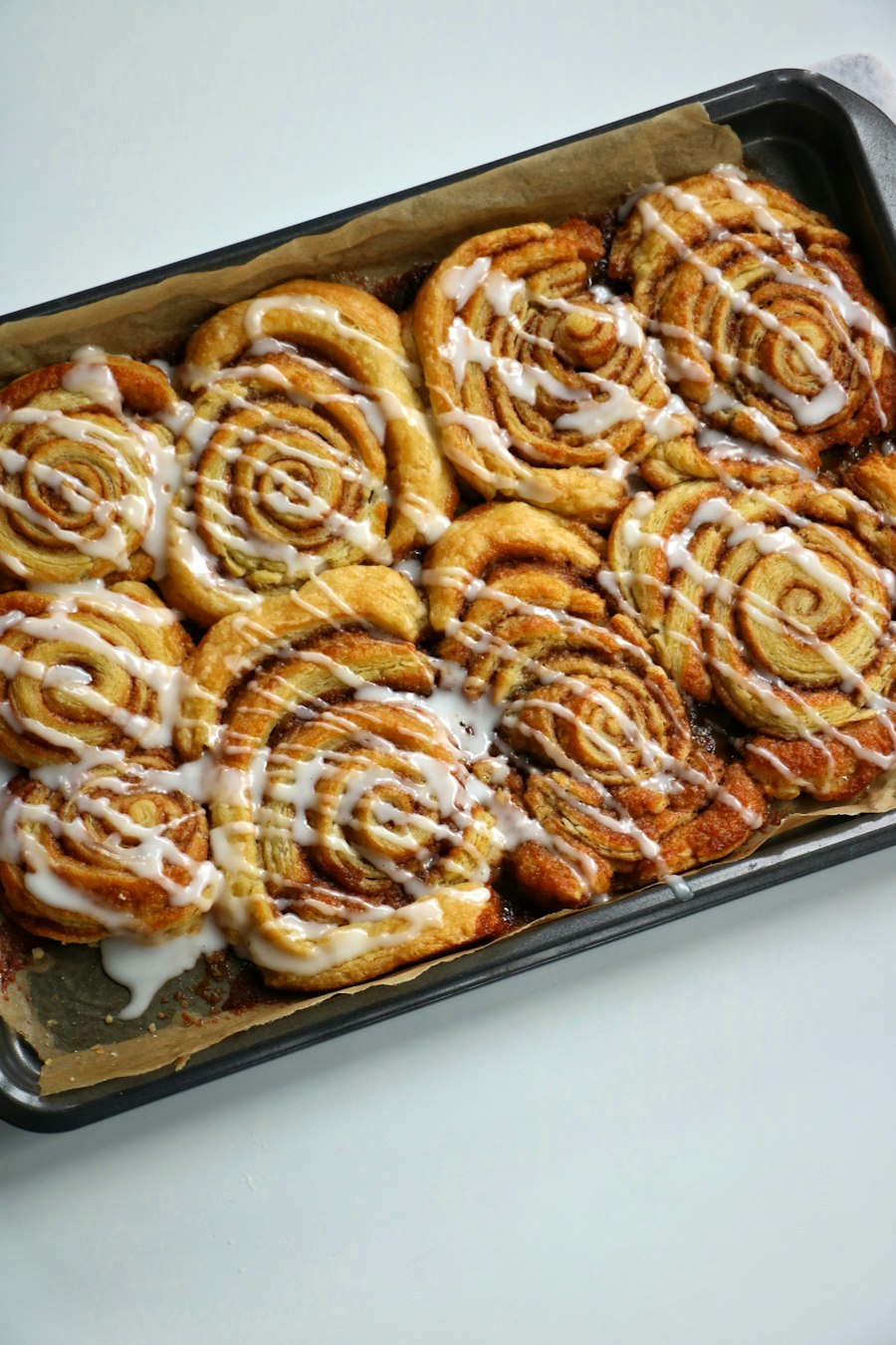A pan of cinnamon buns covered in icing