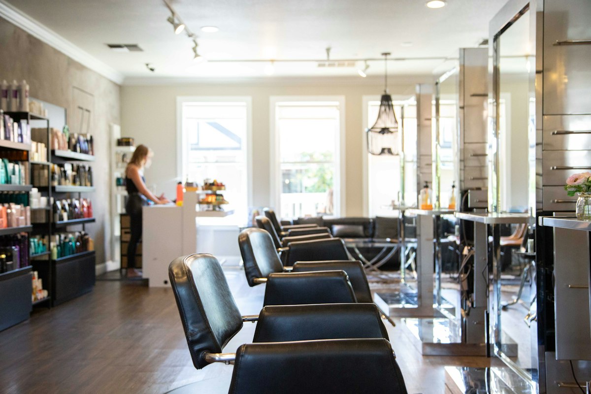 The Maison Vey salon floor, a stylist at the counter preparing for an appointment