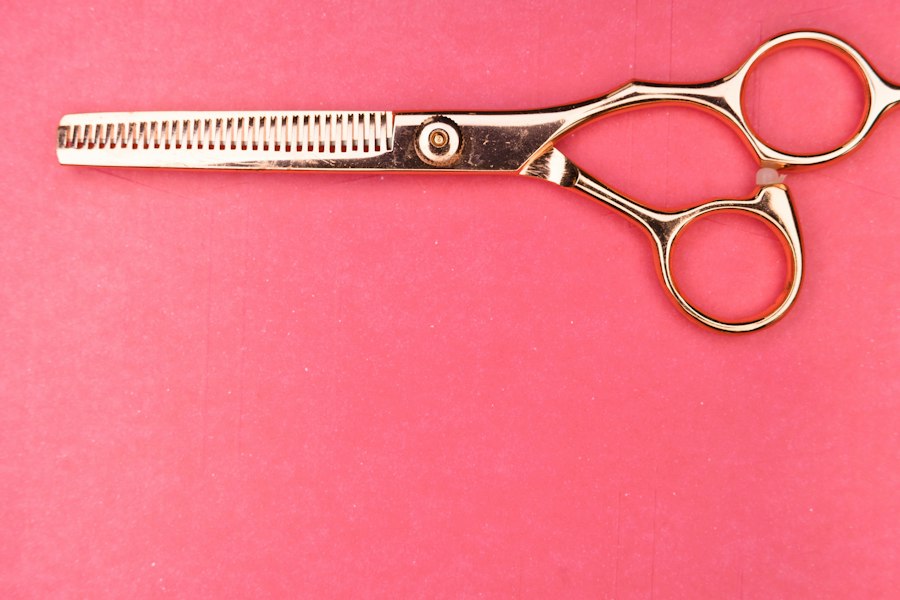 A pair of gold hairdressing scissors, open, on a plain background